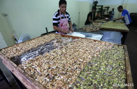 Palestinians prepare sweet known in Arabic as "Halkoum" ahead of the Eid al-Fitr holiday, in Gaza city, on July 3, 2016. Eid al-Fitr marks the end of Muslim's holy fasting month of Ramadan when faithfuls abstain from eat...