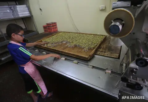 Palestinians prepare sweet known in Arabic as "Halkoum" ahead of the Eid al-Fitr holiday, in Gaza city, on July 3, 2016. Eid al-Fitr marks the end of Muslim's holy fasting month of Ramadan when faithfuls abstain from eat...