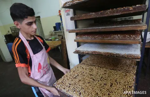 Palestinians prepare sweet known in Arabic as "Halkoum" ahead of the Eid al-Fitr holiday, in Gaza city, on July 3, 2016. Eid al-Fitr marks the end of Muslim's holy fasting month of Ramadan when faithfuls abstain from eat...