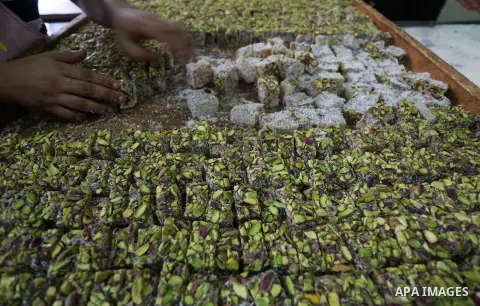 Palestinians prepare sweet known in Arabic as "Halkoum" ahead of the Eid al-Fitr holiday, in Gaza city, on July 3, 2016. Eid al-Fitr marks the end of Muslim's holy fasting month of Ramadan when faithfuls abstain from eat...