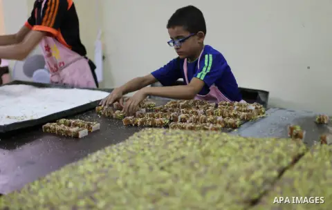 Palestinians prepare sweet known in Arabic as "Halkoum" ahead of the Eid al-Fitr holiday, in Gaza city, on July 3, 2016. Eid al-Fitr marks the end of Muslim's holy fasting month of Ramadan when faithfuls abstain from eat...