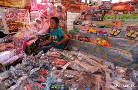 Palestinians shop at a market ahead of the Eid al-Fitr holiday, in Gaza city, on July 4, 2016. Eid al-Fitr marks the end of Muslim's holy fasting month of Ramadan when faithfuls abstain from eating, drinking, smoking and...