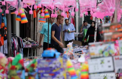 Palestinians shop at a market ahead of the Eid al-Fitr holiday, in Gaza city, on July 4, 2016. Eid al-Fitr marks the end of Muslim's holy fasting month of Ramadan when faithfuls abstain from eating, drinking, smoking and...