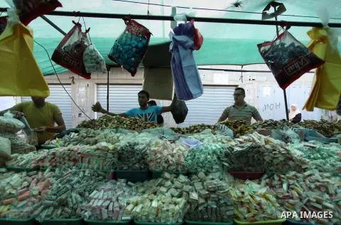 Palestinians shop at a market ahead of the Eid al-Fitr holiday, in Nuseirat refugee camp in the central Gaza Strip, on July 4, 2016. Eid al-Fitr marks the end of Muslim's holy fasting month of Ramadan when faithfuls abst...