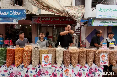 Palestinians shop at a market ahead of the Eid al-Fitr holiday, in Nuseirat refugee camp in the central Gaza Strip, on July 4, 2016. Eid al-Fitr marks the end of Muslim's holy fasting month of Ramadan when faithfuls abst...