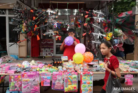 Palestinians shop at a market ahead of the Eid al-Fitr holiday, in Nuseirat refugee camp in the central Gaza Strip, on July 4, 2016. Eid al-Fitr marks the end of Muslim's holy fasting month of Ramadan when faithfuls abst...
