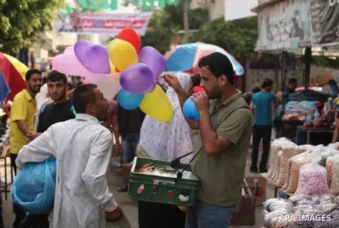 Palestinians shop at a market ahead of the Eid al-Fitr holiday, in Nuseirat refugee camp in the central Gaza Strip, on July 4, 2016. Eid al-Fitr marks the end of Muslim's holy fasting month of Ramadan when faithfuls abst...