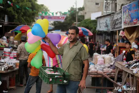 Palestinians shop at a market ahead of the Eid al-Fitr holiday, in Nuseirat refugee camp in the central Gaza Strip, on July 4, 2016. Eid al-Fitr marks the end of Muslim's holy fasting month of Ramadan when faithfuls abst...