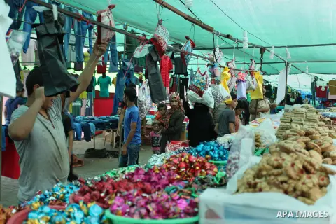 Palestinians shop at a market ahead of the Eid al-Fitr holiday, in Nuseirat refugee camp in the central Gaza Strip, on July 4, 2016. Eid al-Fitr marks the end of Muslim's holy fasting month of Ramadan when faithfuls abst...