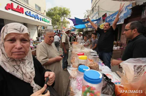 Palestinians shop at a market ahead of the Eid al-Fitr holiday, in Nuseirat refugee camp in the central Gaza Strip, on July 4, 2016. Eid al-Fitr marks the end of Muslim's holy fasting month of Ramadan when faithfuls abst...