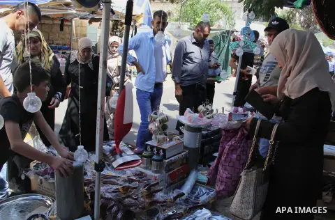 Palestinians shop at a market ahead of the Eid al-Fitr holiday, in Jerusalem old city, on July 3, 2016. Eid al-Fitr marks the end of Muslim's holy fasting month of Ramadan when faithfuls abstain from eating, drinking, sm...