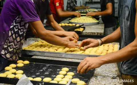 Egyptian bakers prepare date-filled mini cakes traditional for the Eid al-Fitr a three-day holiday that marks the end of the fasting month of Ramadan, at shop in Cairo, Egypt, on July 4, 2016, as Muslims the world over p...
