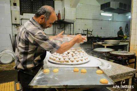 Egyptian bakers prepare date-filled mini cakes traditional for the Eid al-Fitr a three-day holiday that marks the end of the fasting month of Ramadan, at shop in Cairo, Egypt, on July 4, 2016, as Muslims the world over p...