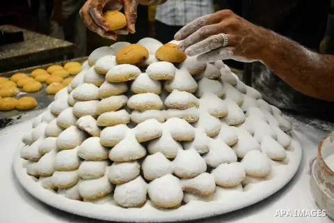 Egyptian bakers prepare date-filled mini cakes traditional for the Eid al-Fitr a three-day holiday that marks the end of the fasting month of Ramadan, at shop in Cairo, Egypt, on July 4, 2016, as Muslims the world over p...