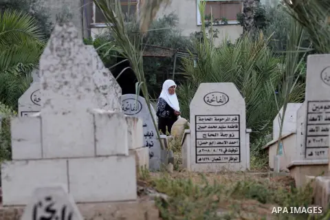 Palestinian women visit the graves of relatives at a cemetery on the first day of Eid al-Fitr celebrations, which marks the end of the holy fasting month of Ramadan, in the West Bank city of Nablus, on July 6, 2016. Phot...