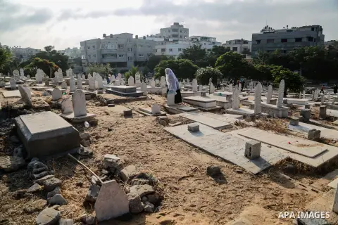 A Palestinian woman visits the grave of her relative at a cemetery on the first day of Eid al-Fitr celebrations, which marks the end of the holy fasting month of Ramadan, in Gaza City July 6, 2016. Photo by Mohammed Dahm...