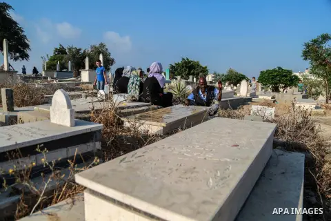 Palestinians visit the grave of their relative at a cemetery on the first day of Eid al-Fitr celebrations, which marks the end of the holy fasting month of Ramadan, in Gaza City July 6, 2016. Photo by Mohammed Dahman