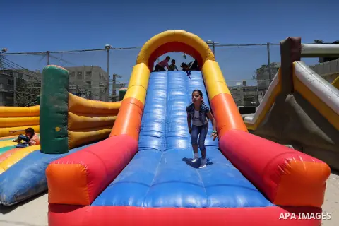 Palestinian children play on the second day of of Eid al-Fitr celebrations, which marks the end of the holy fasting month of Ramadan, at the al-Shati refugee camp in Gaza City on July 7, 2016. Photo by Mohammed Asad
