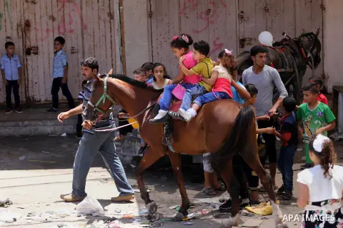 Palestinian children play on the second day of of Eid al-Fitr celebrations, which marks the end of the holy fasting month of Ramadan, at the al-Shati refugee camp in Gaza City on July 7, 2016. Photo by Mohammed Asad