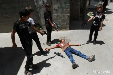 Palestinian boys play with toy guns to celebrate Eid al-Fitr during the second day of the holiday of Eid al-Fitr marking the end of Islam's fasting holy month of Ramadan, in Rafah in the southern Gaza strip, on July 7, 2...
