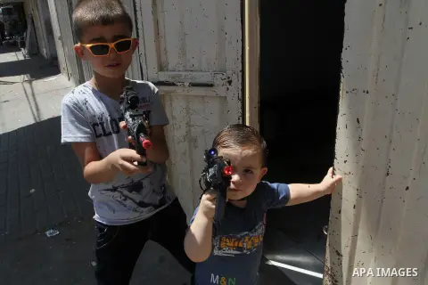 Palestinian boys play with toy guns to celebrate Eid al-Fitr during the second day of the holiday of Eid al-Fitr marking the end of Islam's fasting holy month of Ramadan, in Rafah in the southern Gaza strip, on July 7, 2...