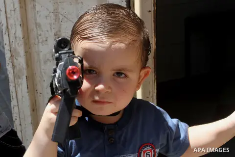 Palestinian boys play with toy guns to celebrate Eid al-Fitr during the second day of the holiday of Eid al-Fitr marking the end of Islam's fasting holy month of Ramadan, in Rafah in the southern Gaza strip, on July 7, 2...