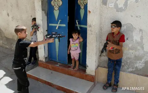 Palestinian boys play with toy guns to celebrate Eid al-Fitr during the second day of the holiday of Eid al-Fitr marking the end of Islam's fasting holy month of Ramadan, in Rafah in the southern Gaza strip, on July 7, 2...