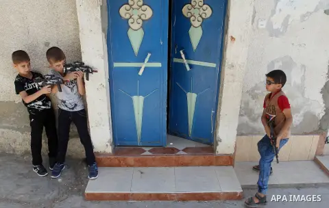 Palestinian boys play with toy guns to celebrate Eid al-Fitr during the second day of the holiday of Eid al-Fitr marking the end of Islam's fasting holy month of Ramadan, in Rafah in the southern Gaza strip, on July 7, 2...