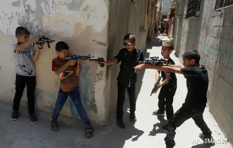 Palestinian boys play with toy guns to celebrate Eid al-Fitr during the second day of the holiday of Eid al-Fitr marking the end of Islam's fasting holy month of Ramadan, in Rafah in the southern Gaza strip, on July 7, 2...