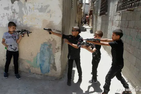 Palestinian boys play with toy guns to celebrate Eid al-Fitr during the second day of the holiday of Eid al-Fitr marking the end of Islam's fasting holy month of Ramadan, in Rafah in the southern Gaza strip, on July 7, 2...