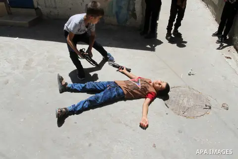 Palestinian boys play with toy guns to celebrate Eid al-Fitr during the second day of the holiday of Eid al-Fitr marking the end of Islam's fasting holy month of Ramadan, in Rafah in the southern Gaza strip, on July 7, 2...