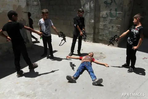 Palestinian boys play with toy guns to celebrate Eid al-Fitr during the second day of the holiday of Eid al-Fitr marking the end of Islam's fasting holy month of Ramadan, in Rafah in the southern Gaza strip, on July 7, 2...