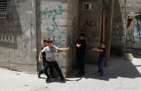 Palestinian boys play with toy guns to celebrate Eid al-Fitr during the second day of the holiday of Eid al-Fitr marking the end of Islam's fasting holy month of Ramadan, in Rafah in the southern Gaza strip, on July 7, 2...