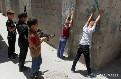 Palestinian boys play with toy guns to celebrate Eid al-Fitr during the second day of the holiday of Eid al-Fitr marking the end of Islam's fasting holy month of Ramadan, in Rafah in the southern Gaza strip, on July 7, 2...