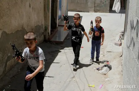 Palestinian boys play with toy guns to celebrate Eid al-Fitr during the second day of the holiday of Eid al-Fitr marking the end of Islam's fasting holy month of Ramadan, in Rafah in the southern Gaza strip, on July 7, 2...