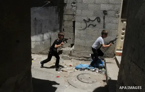 Palestinian boys play with toy guns to celebrate Eid al-Fitr during the second day of the holiday of Eid al-Fitr marking the end of Islam's fasting holy month of Ramadan, in Rafah in the southern Gaza strip, on July 7, 2...