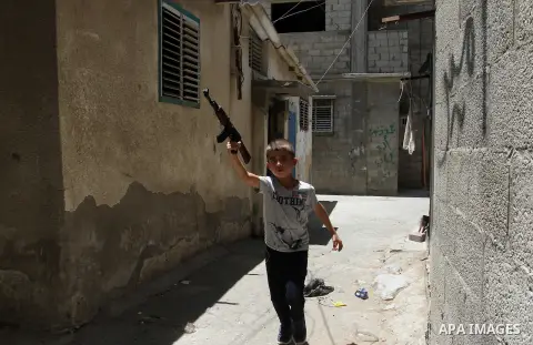 Palestinian boys play with toy guns to celebrate Eid al-Fitr during the second day of the holiday of Eid al-Fitr marking the end of Islam's fasting holy month of Ramadan, in Rafah in the southern Gaza strip, on July 7, 2...