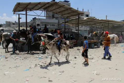 Palestinian children play to celebrate Eid al-Fitr during the second day of the holiday of Eid al-Fitr marking the end of Islam's fasting holy month of Ramadan, in Rafah in the southern Gaza strip, on July 7, 2016. Photo...