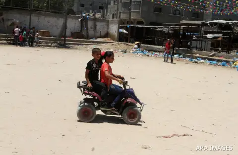 Palestinian children play to celebrate Eid al-Fitr during the second day of the holiday of Eid al-Fitr marking the end of Islam's fasting holy month of Ramadan, in Rafah in the southern Gaza strip, on July 7, 2016. Photo...