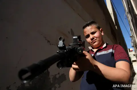 Palestinian boys play with toy guns to celebrate Eid al-Fitr during the second day of the holiday of Eid al-Fitr marking the end of Islam's fasting holy month of Ramadan, in the West Bank city of Nablus, on July 7, 2016....