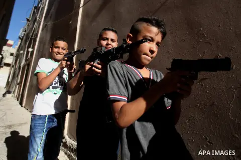 Palestinian boys play with toy guns to celebrate Eid al-Fitr during the second day of the holiday of Eid al-Fitr marking the end of Islam's fasting holy month of Ramadan, in the West Bank city of Nablus, on July 7, 2016....