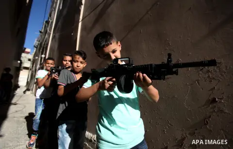 Palestinian boys play with toy guns to celebrate Eid al-Fitr during the second day of the holiday of Eid al-Fitr marking the end of Islam's fasting holy month of Ramadan, in the West Bank city of Nablus, on July 7, 2016....