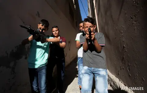 Palestinian boys play with toy guns to celebrate Eid al-Fitr during the second day of the holiday of Eid al-Fitr marking the end of Islam's fasting holy month of Ramadan, in the West Bank city of Nablus, on July 7, 2016....