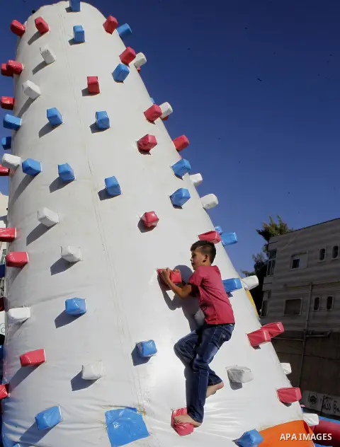 Palestinian children play to celebrate Eid al-Fitr during the second day of the holiday of Eid al-Fitr marking the end of Islam's fasting holy month of Ramadan, in the West Bank city of Hebron, on July 7, 2016. Photo by...