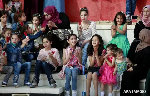 Palestinian children play to celebrate Eid al-Fitr during the second day of the holiday of Eid al-Fitr marking the end of Islam's fasting holy month of Ramadan, in the West Bank city of Hebron, on July 7, 2016. Photo by...