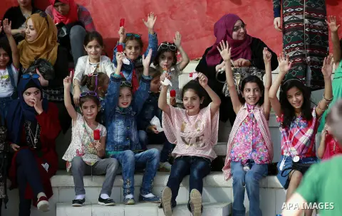 Palestinian children play to celebrate Eid al-Fitr during the second day of the holiday of Eid al-Fitr marking the end of Islam's fasting holy month of Ramadan, in the West Bank city of Hebron, on July 7, 2016. Photo by...