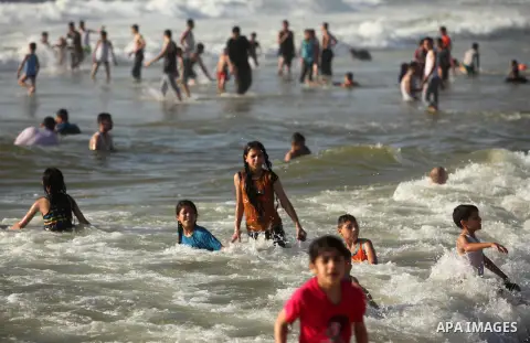 Palestinian children swim in the Mediterranean sea on the coast of Gaza city, on the third day of Eid al-Fitr holiday which marks the end of the Muslim holy month of Ramadan, on July 08, 2016. Photo by Ashraf Amra