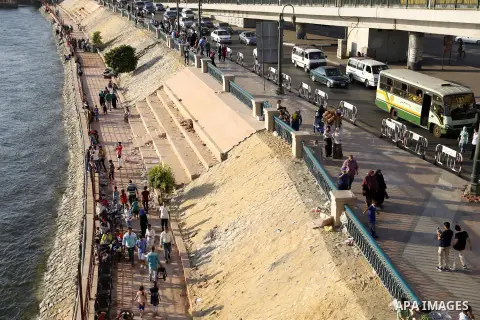 Egyptians walk past Nile River on the third day of Eid al-Fitr holiday which marks the end of the Muslim holy month of Ramadan, in Cairo, Egypt, on July 08, 2016. Photo by Amr Sayed
