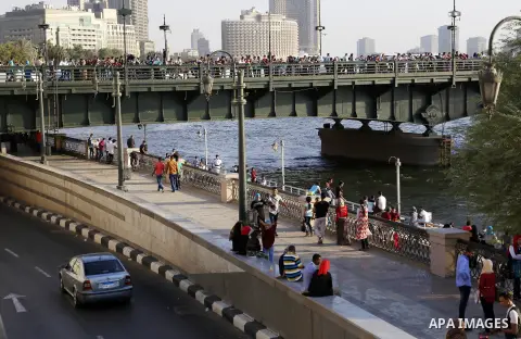 Egyptians walk past Nile River on the third day of Eid al-Fitr holiday which marks the end of the Muslim holy month of Ramadan, in Cairo, Egypt, on July 08, 2016. Photo by Amr Sayed