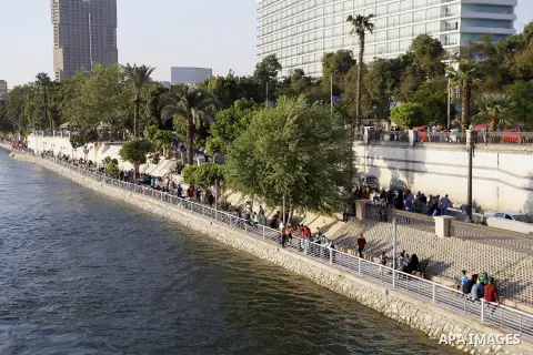 Egyptians walk past Nile River on the third day of Eid al-Fitr holiday which marks the end of the Muslim holy month of Ramadan, in Cairo, Egypt, on July 08, 2016. Photo by Amr Sayed